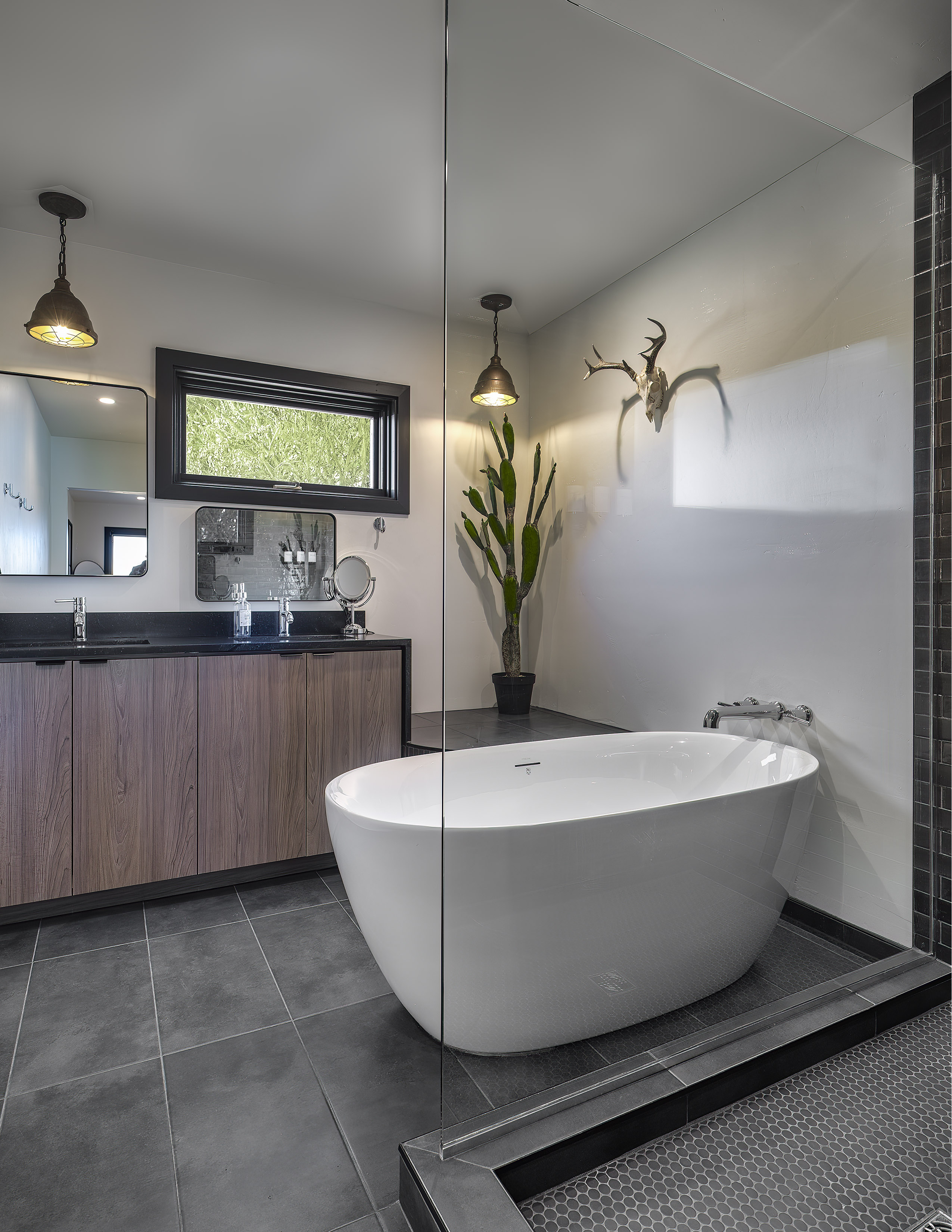Freestanding soaking tub with deer skull art and glass partition
